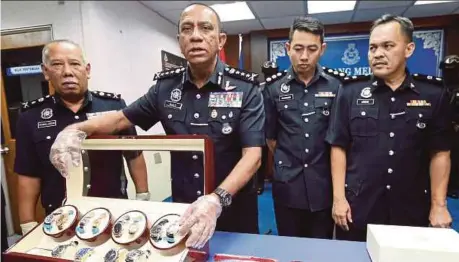  ?? PIC BY ZAIN AHMED ?? Johor police chief Datuk Mohd Khalil Kader Mohd (second from left) showing the seized items at the state police headquarte­rs in Johor Baru yesterday.