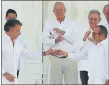  ??  ?? PEACE AT LAST: Colombia’s President Juan Manuel Santos, left, gives a peace pin to FARC commander Rodrigo Londono.