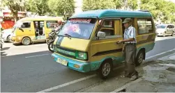  ?? HANUNG HAMBARA/JAWA POS ?? NGETEM: Totok Hermawan menunggu keberangka­tan angkot yang berhenti di Jalan Kenjeran.