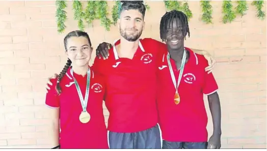  ?? ?? Los jóvenes atletas de la Escuela de Medina Sidonia, con las medallas que les acreditan como campeones y junto a su entrenador, Manuel Camacho.