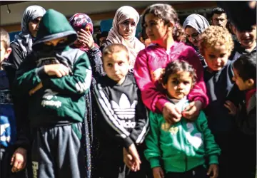  ?? — AFP photo ?? Photo shows Iraqi Yazidi women and children rescued from the Islamic State (IS) group waiting to board buses bound for Sinjar in Iraq’s Yazidi heartland.