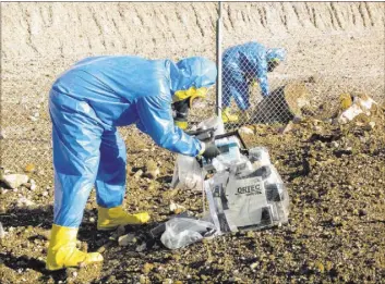  ?? MAJ. NATE TAYLOR/NEVADA ARMY NATIONAL GUARD ?? A team surveys the eruption site Oct. 19, 2015, at the low-level radioactiv­e waste landfill 11 miles south of Beatty. An undergroun­d fire triggered a series of eruptions.