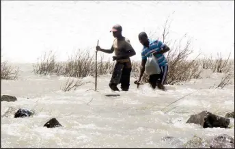  ??  ?? Dicing with death: Two men search for fish from the Lower Ncema Dam spillway on Friday. (See another picture on Page 6)