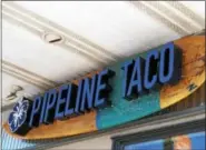  ??  ?? A surfboard greets customers at the entrance of Pipeline Taco.