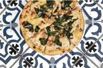  ??  ?? The Florentine pizza includes Alfredo sauce, spinach, grilled chicken and Parmesan cheese.
