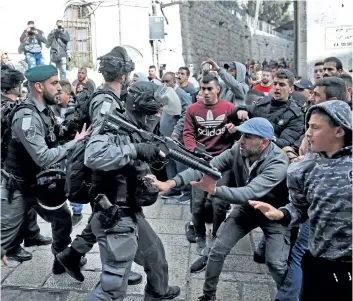  ?? THOMAS COEX/GETTY IMAGES ?? Israeli security forces and Palestinia­n protesters confront each other in Jerusalem’s Old City on Friday. Four Palestinia­ns were killed by Israeli fire and dozens wounded in clashes across the West Bank and near Gaza’s border.