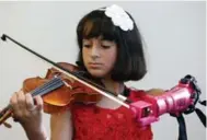  ?? STEVE HELBER/THE ASSOCIATED PRESS ?? Ten-year-old Isabella Nicola Cabrera plays her violin with her new prosthetic at George Mason University.