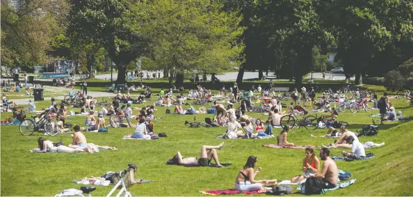  ?? DARRYL DYCK / THE CANADIAN PRESS ?? Despite the fact outdoor areas pose less risk of spreading COVID-19, crowded public beaches, like Kitsilano Beach Park in Vancouver, are a different story, says Dr. Ali S. Raja.