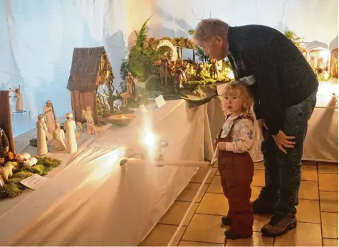  ?? Foto: Rony Schneider ?? Da staunt die vierjährig­e Rosalie Ostermair. Mit ihrem Opa Franz spricht sie über die vielen schönen Krippen im Klosterlec­hfelder Pfarrsaal.