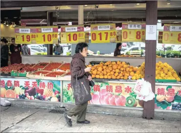  ?? PHOTO: EPA ?? A Chinese consumer chooses fruit and vegetables at a shop in Hutong neighbourh­ood in Beijing, China, yesterday. China’s gross domestic product grew 6.9 percent in the first quarter of the year, according to the National Bureau of Statistics.