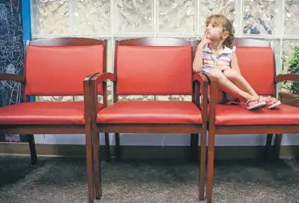  ??  ?? RIGHT: Lexi sits in the waiting room while her mother checks her in for her biannual heart exam Aug. 8.