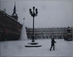  ?? ANDREA COMAS — THE ASSOCIATED PRESS ?? A woman skis while crossing the Plaza Mayor in Madrid during a heavy snowfall in Madrid on Saturday.