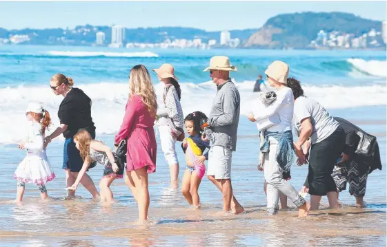  ?? Picture: MIKE BATTERHAM ?? Family and friends, including parents John and Karen, scatter the ashes of Jesse Bird at Northcliff SLSC yesterday.