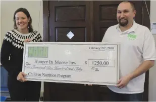  ??  ?? Executive Director at Hunger in Moose Jaw, Sharla Sept accepts a donation from Kristian Sjoberg of the Moose Jaw Gamers Associatio­n.