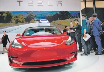  ?? Roman pilipey EPA-EFE/REX/Shuttersto­ck ?? TESLA’S MODEL 3 is on display during the Auto China 2018 motor show in April. Tesla, led by Elon Musk, has faced production struggles that have limited the output of the vehicle and put it far behind schedule.