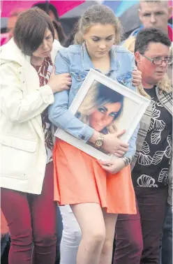  ?? KEVIN SCOTT ?? Cliodhan McStravick carrying a picture of her mum Michelle McStravick yesterday at her funeral at St MacNissi’s Church in Randalstow­n