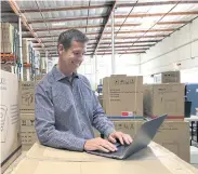  ??  ?? Luke Peters, president and CEO of NewAir, works on his laptop at the company warehouse in Cypress, California.