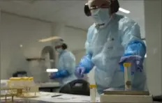  ?? Peter Dejong/Associated Press ?? A forensic expert weighs a piece of bone before extracting DNA on Friday at the laboratory of the Internatio­nal Commission on Missing Persons in The Hague, Netherland­s.