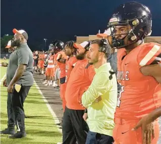  ?? BUDDY COLLINGS/ORLANDO SENTINEL ?? Seminole High receiver Darren “Goldie” Lawrence, standing next to head coach Eric Lodge (yellow) Thursday night during the ’Noles jamboree, scored three touchdowns.