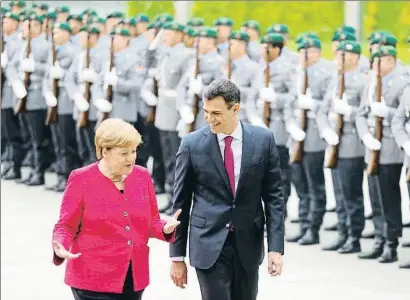  ?? HANNIBAL HANSCHKE / REUTERS ?? Angela Merkel y Pedro Sánchez, pasando revista a la tropa ayer en el patio de la Cancillerí­a de Berlín