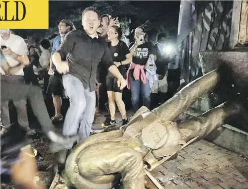  ?? JULIA WALL / THE NEWS & OBSERVER VIA AP ?? Protesters celebrate after the Confederat­e statue known as “Silent Sam” was toppled on the campus of the University of North Carolina in Chapel Hill, N.C., during a demonstrat­ion on Monday.