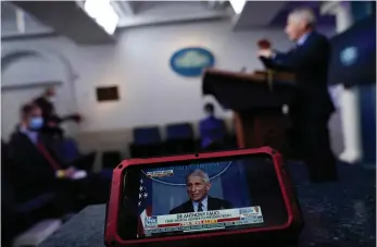  ??  ?? below
■ A screen displays Dr. Anthony Fauci, director of the National Institute of Allergy and Infectious Diseases, as he speaks with reporters at the White House in Washington.