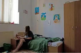  ?? ?? Latika Nikolaiev, 12, of Sumy, Ukraine, paints on a bed in his family’s apartment on June 12. The Nikolaievs’ space consists of two rooms and a kitchen in Oradea, Romania.