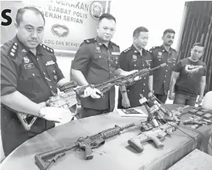  ??  ?? ASWANDY (dua kiri) bersama pegawai kanan polis IPD Serian menunjukka­n senjata tiruan yang dirampas daripada suspek.