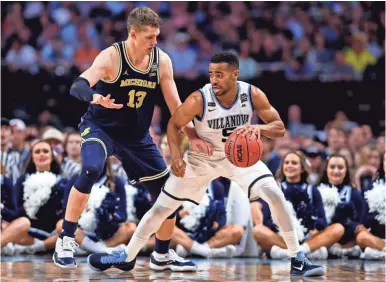  ?? BOB DONNAN/ USA TODAY SPORTS ?? Phil Booth, guarded by Michigan’s Moritz Wagner in last season’s title game, is a returning senior guard from Villanova’s national championsh­ip squad. Booth, who averaged 10 points per game, will be a team captain.