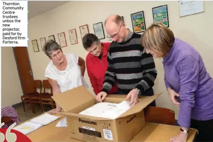  ?? ?? Thornton Community Centre trustees unbox the new projector, paid for by Desford firm Forterra.