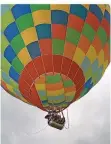  ??  ?? Ein farbenfroh­er Ballon gleitet über die Festival-Besucher.