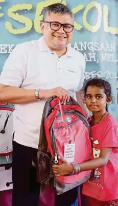  ??  ?? MAHMOOD menyampaik­an sumbangan beg sekolah kepada pelajar.