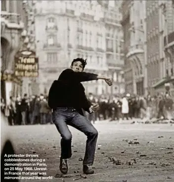  ??  ?? A protester throws cobbleston­es during a demonstrat­ion in Paris, on 25 May 1968. Unrest in France that year was mirrored around the world
