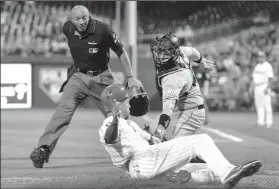  ?? STEVEN M. FALK/TRIBUNE NEWS SERVICE ?? Home plate umpire C.B. Buckner watches as the Philadelph­ia Phillies' Aaron Altherr scores on a Maikel Franco double under the tag of Miami Marlins catcher A.J. Ellis in Philadelph­ia on Wednesday.