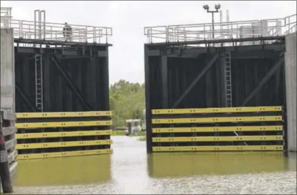  ?? MATTHEW HINTON — THE ASSOCIATED PRESS ?? The Caernarvon, La., floodgate closes Friday in St. Bernard Parish before the arrival of Hurricane Nate. Many fisherman and crab trappers were allowed to dock their boats inside the floodgate.