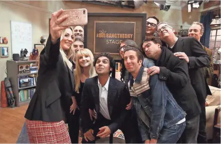  ?? WARNER BROS. ?? Kaley Cuoco, left, takes a group photo of “The Big Bang Theory” cast and producers just after Warner Bros. dedicated the Burbank soundstage to the top-rated CBS comedy, which finishes its 12-season run in May.