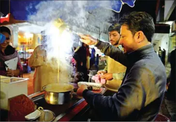  ?? FAROOQ NAEEM/AFP ?? A Pakistani worker prepares tandoori tea at a market stall in Islamabad.