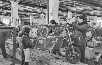  ?? PROVIDED TO CHINA DAILY ?? Employees assemble an electric tricycle at a factory in Wuxi, Jiangsu province, on Jan 26.