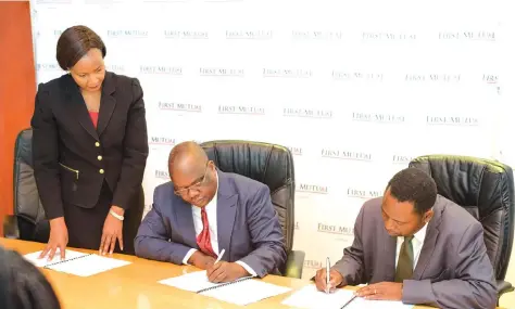  ??  ?? First Mutual Holdings Limited chief executive Mr Douglas Hoto (centre) and Reformed Church University vice chancellor Professor Wiseman Magwa (right) sign the memorandum of understand­ing for the scholarshi­p fund while FML group marketing and strategy...
