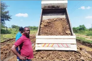  ?? (Pics: Sabelo Ndzinisa) ?? Lugongolwe­ni Bucopho Mpendulo Simelane watching as his tipper truck delivers soil that is used to regravel one of the damaged roads in Matsetsa. Next to him is the area’s Indvuna Yenkhundla Jabulani Mamba.