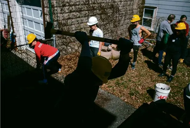  ?? JONATHAN WIGGS/GLOBE STAFF ?? Alan Palm, equipped with a sledgehamm­er, joined Green & Open Somerville on its first “depavement” event of the year. According to its website, the group advocates for improving and increasing green space in Somerville by replacing concrete and asphalt with dirt.