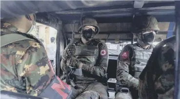  ??  ?? 0 Soldiers sit inside a military truck outside a Hindu temple in Yangon yesterday