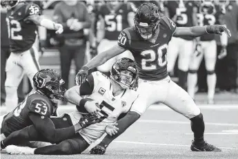  ?? Brett Coomer / Staff photograph­er ?? Texans linebacker Duke Ejiofor, left, and safety Justin Reid stop Jaguars quarterbac­k Blake Bortles short of a first down after he was forced out of the pocket in the second quarter.