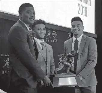  ?? RALPH RUSSO/AP PHOTO ?? Heisman Trophy finalists, from left, Dwayne Haskins of Ohio State, Kyler Murray of Oklahoma, and Tua Tagovailoa of Alabama, pose with the Heisman Trophy at the New York Stock Exchange on Friday.