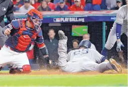  ?? PHIL LONG/ASSOCIATED PRESS ?? Cleveland catcher Roberto Perez is late on the tag as New York’s Todd Frazier slides in safely at home in the ninth inning with the Yankees’ fifth run of the game. He took advantage of a throwing error by outfielder Jay Bruce.