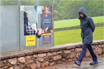  ?? BOB EDME, AP ?? Posters of Emmanuel Macron, left, and Marine Le Pen adorn a wall in Ascain, France, on May 2.