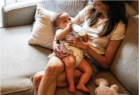  ?? TOM GRALISH/ PHILADELPH­IA INQUIRER/TNS ?? Liz Lockerman
feeds her 8-month-old son, Logan, a bottle of infant formula at home on May 31. The infant
formula shortage has exacerbate­d the stigma
parents feel when they don’t breastfeed.