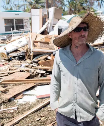  ?? PHOTO AFP ?? Bill Quinn inspectait hier les dommages causés à sa maison mobile lors du passage de l’ouragan Irma dans les Keys.