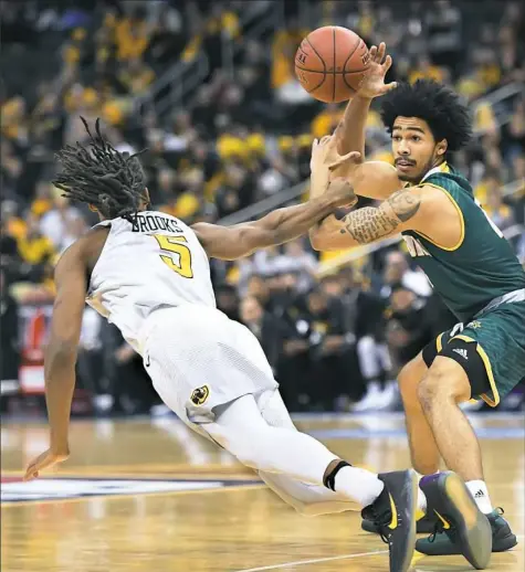  ??  ?? George Mason’s Otis Livingston, right, is fouled by VCU’s Doug Brooks in an Atlantic 10 tournament game Friday at PPG Paints Arena.