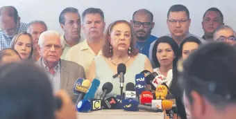  ?? ?? Corina Yoris (c) candidata presidenci­al por PUD, la principal alianza opositora de Venezuela, ayer en rueda de prensa en Caracas. denuncia que no puede inscribir su postulació­n. (EFE).